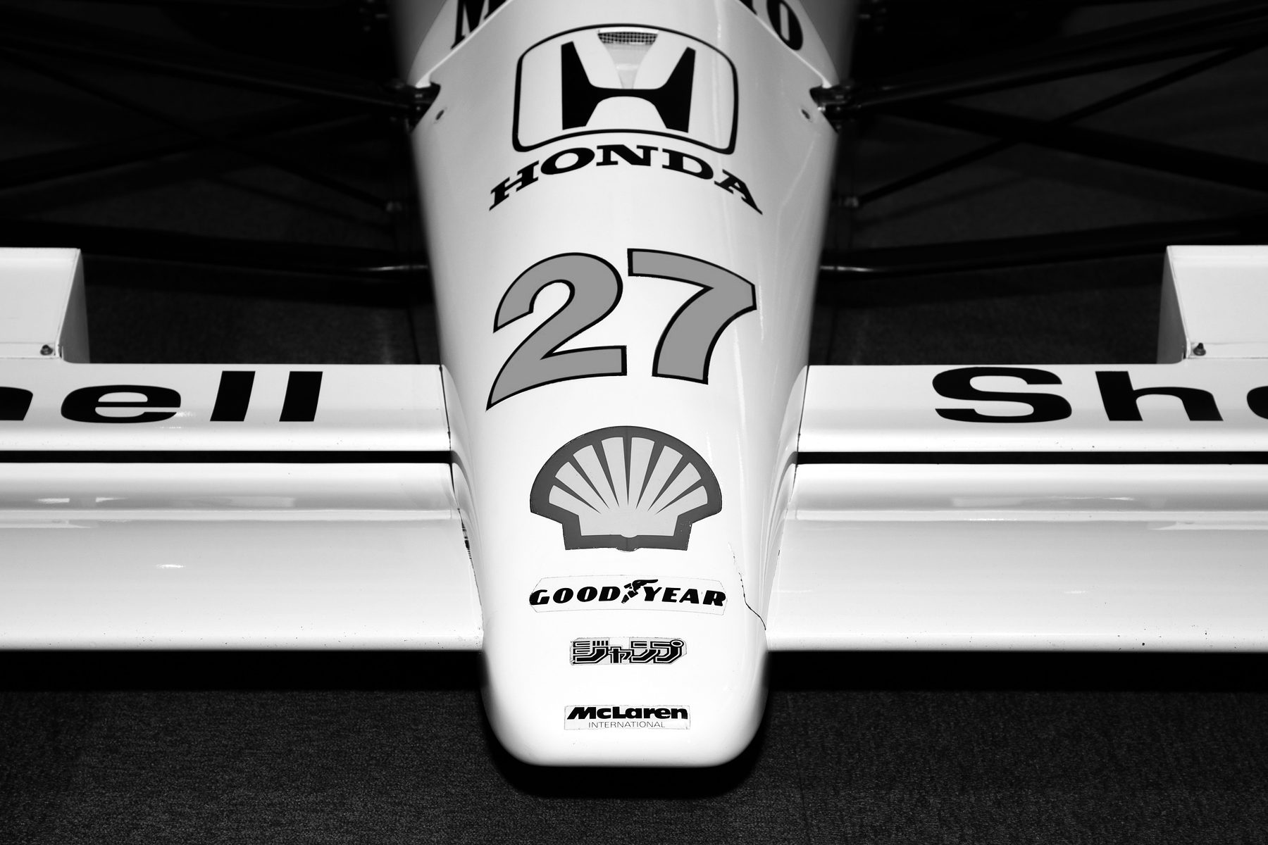 Close-up of the pale nose of a Formula One car: a Honda badge above a large number 27 and a shell emblem, with the front wing spreading out on either side.